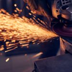 Worker cutting metal with grinder. Sparks while grinding iron